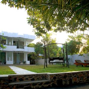 une balançoire dans une cour devant une maison dans l'établissement villa layanga - riverside guestrooms, à Aluthgama