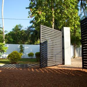 une porte en bois au milieu d'un parc dans l'établissement villa layanga - riverside guestrooms, à Aluthgama