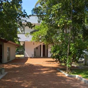 une cour vide d'un bâtiment avec des arbres dans l'établissement villa layanga - riverside guestrooms, à Aluthgama
