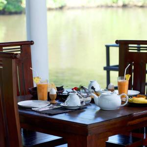a table with a tea set on it with drinks at villa layanga - riverside guestrooms in Aluthgama