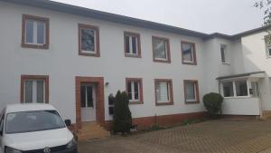 uma casa branca com um carro estacionado em frente dela em ABC-Monteurzimmer em Magdeburg