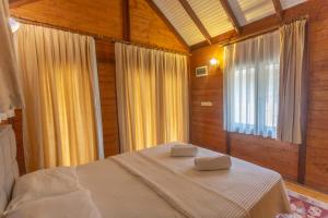 a bedroom with a bed with two towels on it at Sea Valley Lodge in Faralya