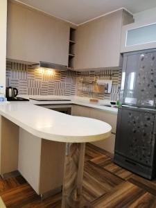 a kitchen with a white counter top and a refrigerator at Coventina Lake Suites in Dhaka
