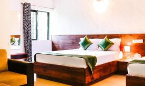a hotel room with a bed and a chair at Itsy By Treebo - Comforts Inn in Mangalore
