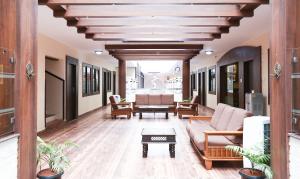 门格洛尔Treebo Comforts Inn, University Road Deralakatte的带沙发和桌子的客厅