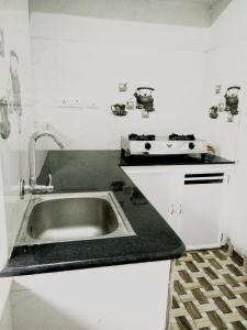 a kitchen with a sink and a stove at Nunu Homestay Guruvayoor in Guruvāyūr
