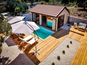 a deck with a swimming pool and a house at Luxury mobile home Maro Biograd in Biograd na Moru