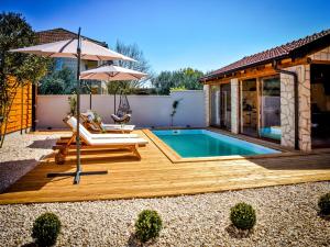 a backyard with a pool and a deck with an umbrella at Luxury mobile home Maro Biograd in Biograd na Moru