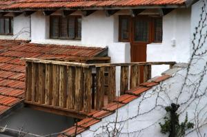 un balcón de madera en una casa con techo rojo en Usadba, en Koktebel