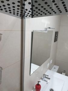 ein Bad mit einem Waschbecken und einem Spiegel in der Unterkunft Cosy Well Located Apartment with swimming pool Tenerife in Tacoronte