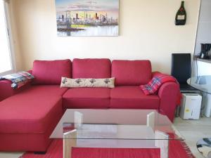 un divano rosso in soggiorno con tavolo in vetro di Cosy Well Located Apartment with swimming pool Tenerife a Tacoronte