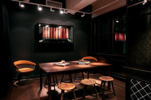 - une salle à manger avec une table et des tabourets en bois dans l'établissement Ruby Coco Hotel Dusseldorf, à Düsseldorf