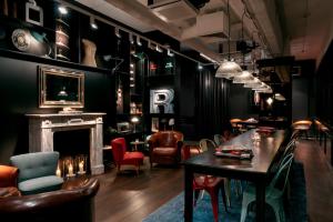 Habitación con mesa, sillas y chimenea. en Ruby Coco Hotel Dusseldorf, en Düsseldorf