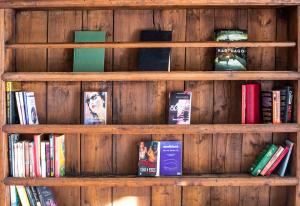 una estantería de madera llena de libros en Langley Hotel La Vieille Ferme, en La Salle-les-Alpes