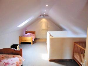 um quarto no sótão com 2 camas e uma escada em La Normandy em Dieppe