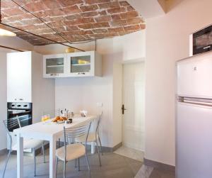 a kitchen and dining room with a white table and chairs at Nonna Pappa in Siena