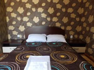 un letto con due cuscini sopra in una camera da letto di Mix Hotel a Vidin