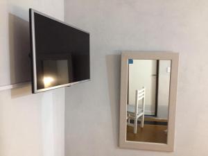 d'un miroir accroché au mur et d'une télévision. dans l'établissement Continental Hotel, à Curuzú Cuatiá