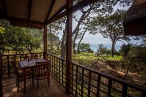 a porch with a table and chairs looking out at the ocean at Sea Valley Lodge in Faralya