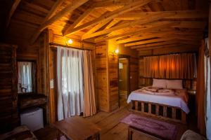 a bedroom in a log cabin with a bed in it at Sea Valley Lodge in Faralya