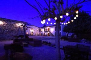 un patio iluminado por la noche con un árbol con luces en B&B El Ranxo en Franciach