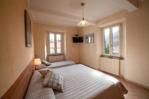 a bedroom with a bed and two windows at Eliseo B&B Ristorante in Gallicano