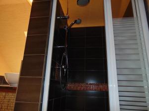 a shower in a bathroom with black tile at Saint-Pierre in Dieppe