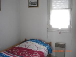 a small bedroom with a bed and a window at appartement T3 très fonctionnel et central au Cap Ferret in Cap-Ferret +11 photos