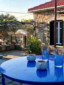een blauwe tafel met twee kommen en een glas water bij HORTO HOUSE in Chorto