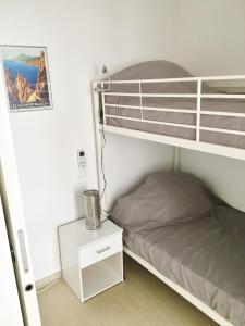 um pequeno quarto com um beliche e uma mesa de cabeceira em CALVI em Calvi