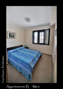 een slaapkamer met een bed met een blauw dekbed bij Il Gelsomino in Favignana