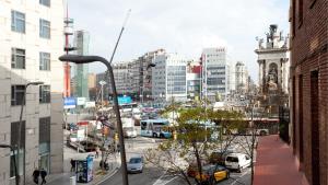 巴塞隆納的住宿－AB Montjuic，一条繁忙的城市街道,有汽车和巴士