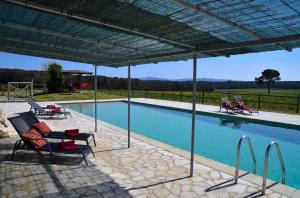 een patio met stoelen en een zwembad bij B&B El Ranxo in Franciach