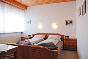 a bedroom with two beds and a desk at Pension "Bayerwald" in Frauenau