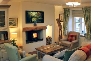 a living room with a couch and a fireplace at The Tree House Cumbria in Beckermet
