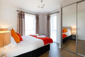 a bedroom with two beds and a large mirror at Contemporary Trumpington Apartment with Self Check-in ,FREE On-site Parking, Terrace, SUPER Fast WIFI & 5 mins drive to Papworth & Addenbrookes hospitals in Cambridge