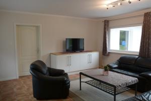 a living room with a couch and a tv at Ferienhaus BAUMBLÜTE in Werder