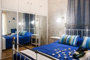 a bedroom with two beds with blue sheets at Pretty rooms in Gold and Blue apartment in safe central area in Athens
