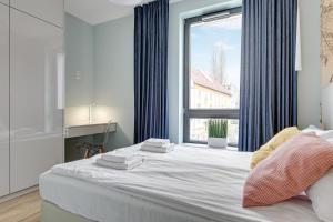 a bedroom with a large bed with a window at Dom & House - Apartments Okrzei Prime in Sopot