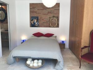 a bedroom with a bed with red pillows and a brick wall at La bulle de Gaston in Toulouse