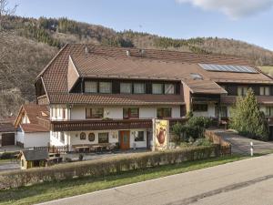 ein großes Haus mit Solardach auf einer Straße in der Unterkunft Café-Pension Endehof in Oberprechtal