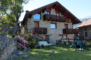 una grande casa in pietra con un giardino di fronte di Maison d'Antan a Introd