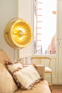 een lamp in een woonkamer naast een bank bij Bib Rambla Luxury Apartments by Apolo Homes in Granada