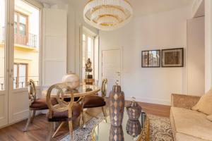 un soggiorno con tavolo e sedie di Bib Rambla Luxury Apartments by Apolo Homes a Granada