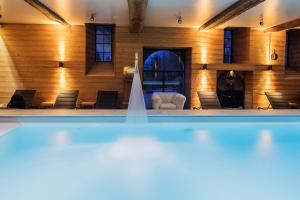 a swimming pool in a room with chairs at Domaine De Villeray in Condeau