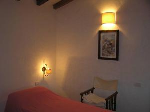 sypialnia z łóżkiem, lampką i krzesłem w obiekcie Bamboo House w mieście Teulada