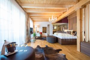 una camera con letto e tavolo con bicchieri da vino di Hotel La Cruna a Sedrun Altre 37 foto
