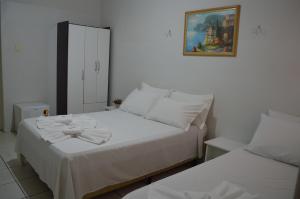 1 dormitorio con 2 camas y una foto en la pared en Touring Hotel, en Maringá