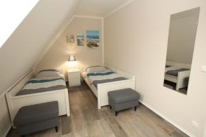 ein kleines Zimmer mit 2 Betten und einem Spiegel in der Unterkunft Familienfreundliches Ferienhaus in Kröpelin in Kröpelin