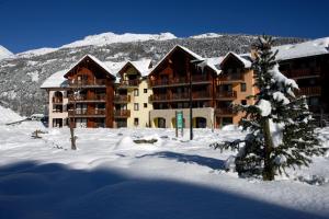 a large building in the snow in front of a mountain at L'Alpaga by Mountain Collection Immobilier in La Salle-les-Alpes